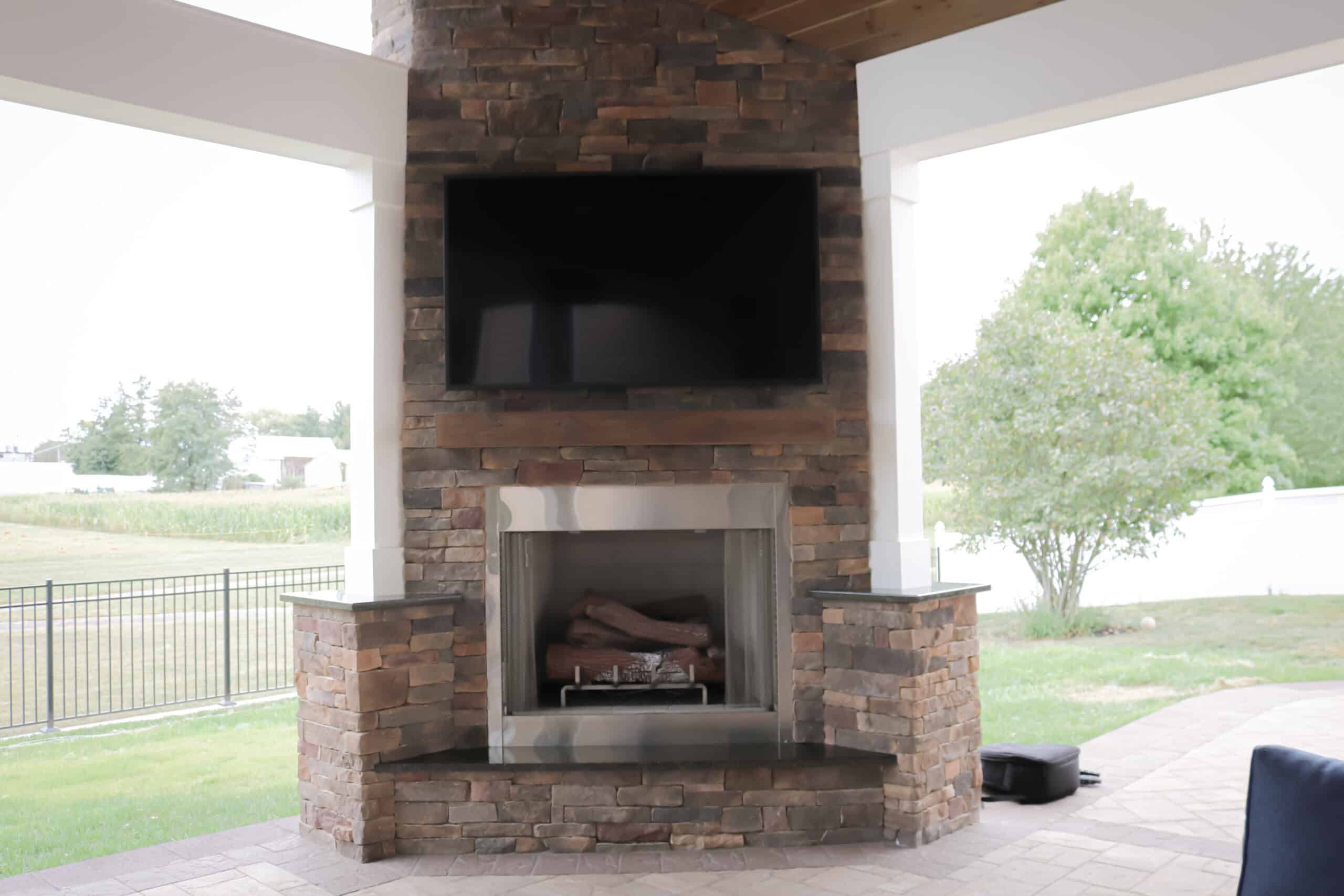 A tv mounted on a brick fireplace.