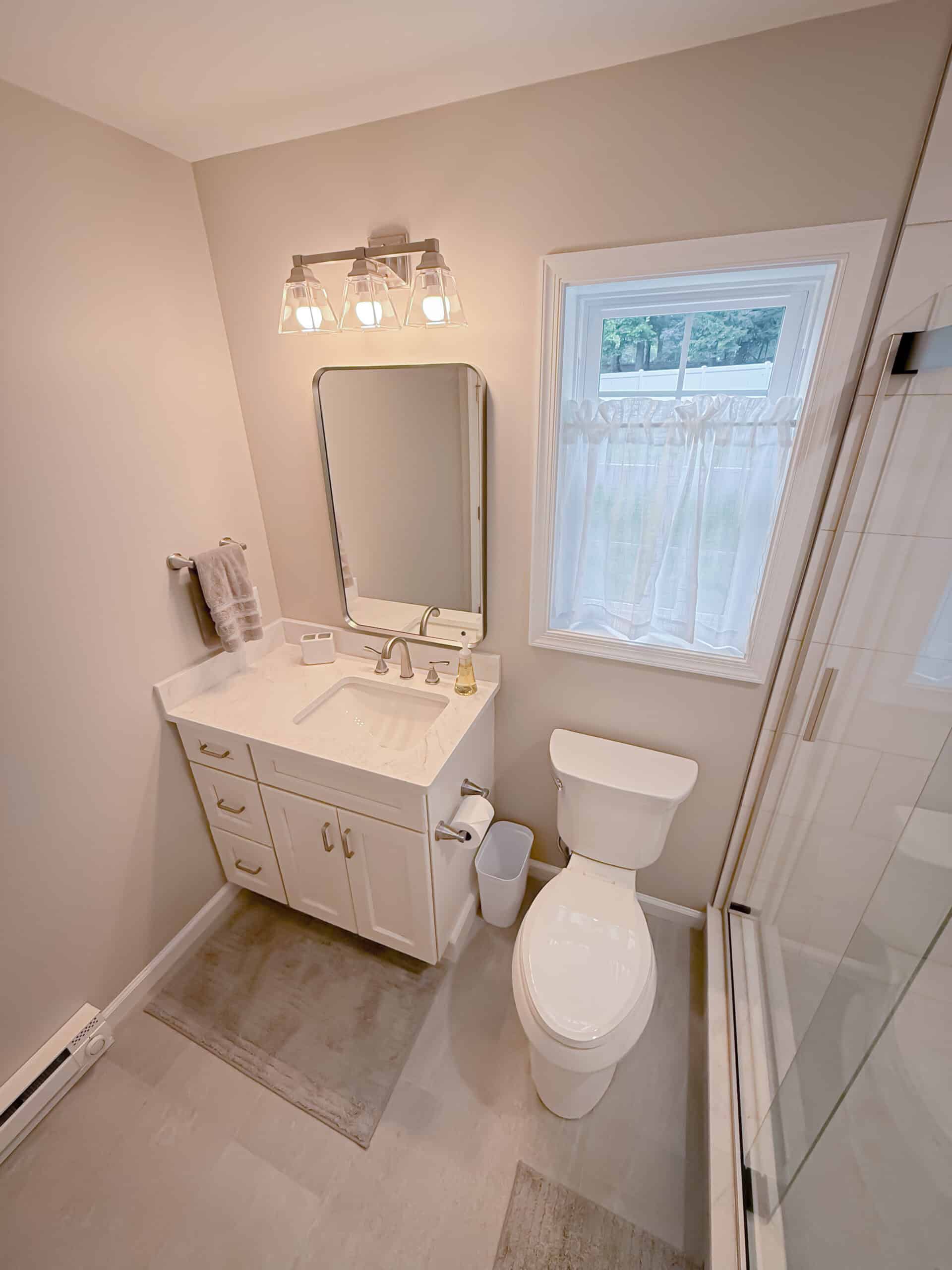 A bathroom with a toilet, sink and shower.