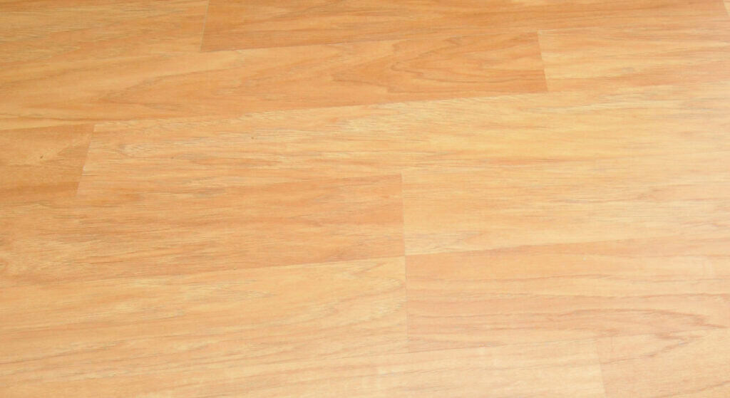 Light brown wooden floor with a smooth finish and visible grain patterns, arranged in a staggered plank design.