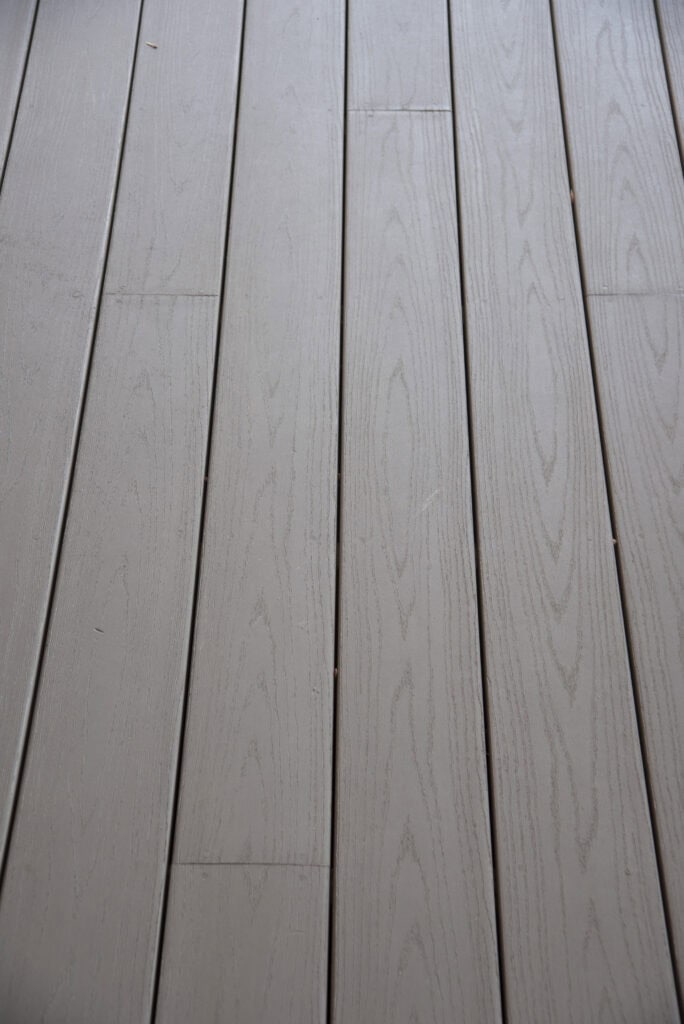 Light gray wooden floorboards with a natural wood grain pattern, arranged in parallel lines. The surface appears clean and well-maintained.