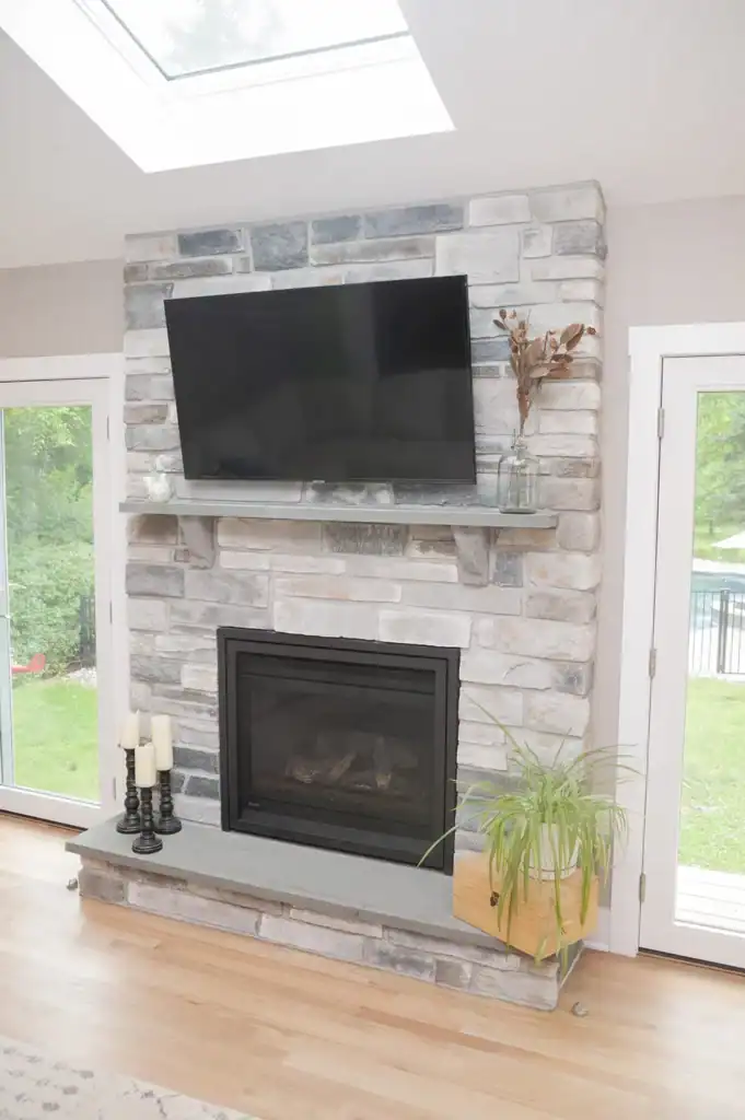 A tv mounted on a brick fireplace.