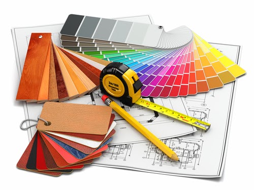 Color swatches, material samples, a yellow tape measure, and a pencil are arranged on top of architectural blueprints, representing tools used in interior design or renovation planning.