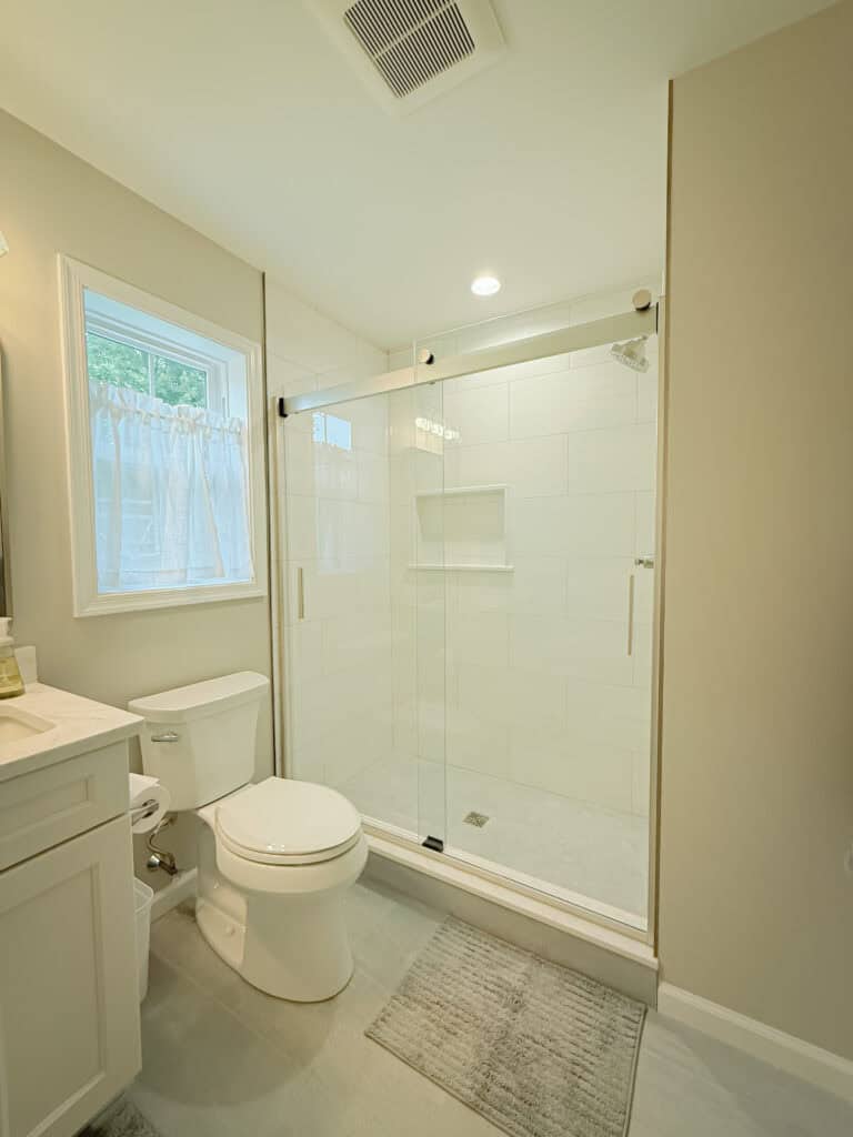 A bathroom with a toilet, sink and shower.