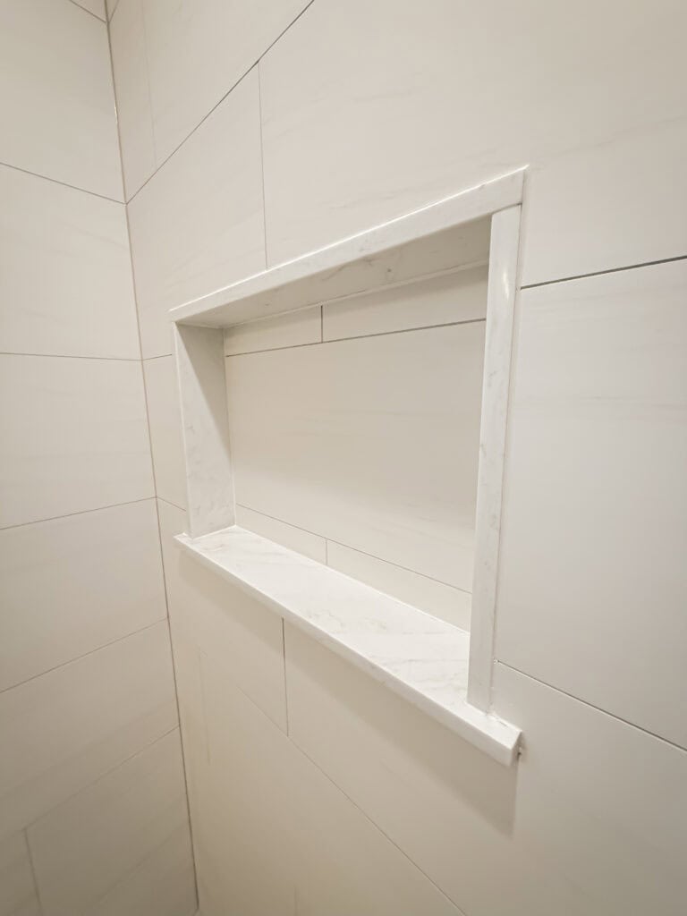 A white tile shower niche by Munz Construction
