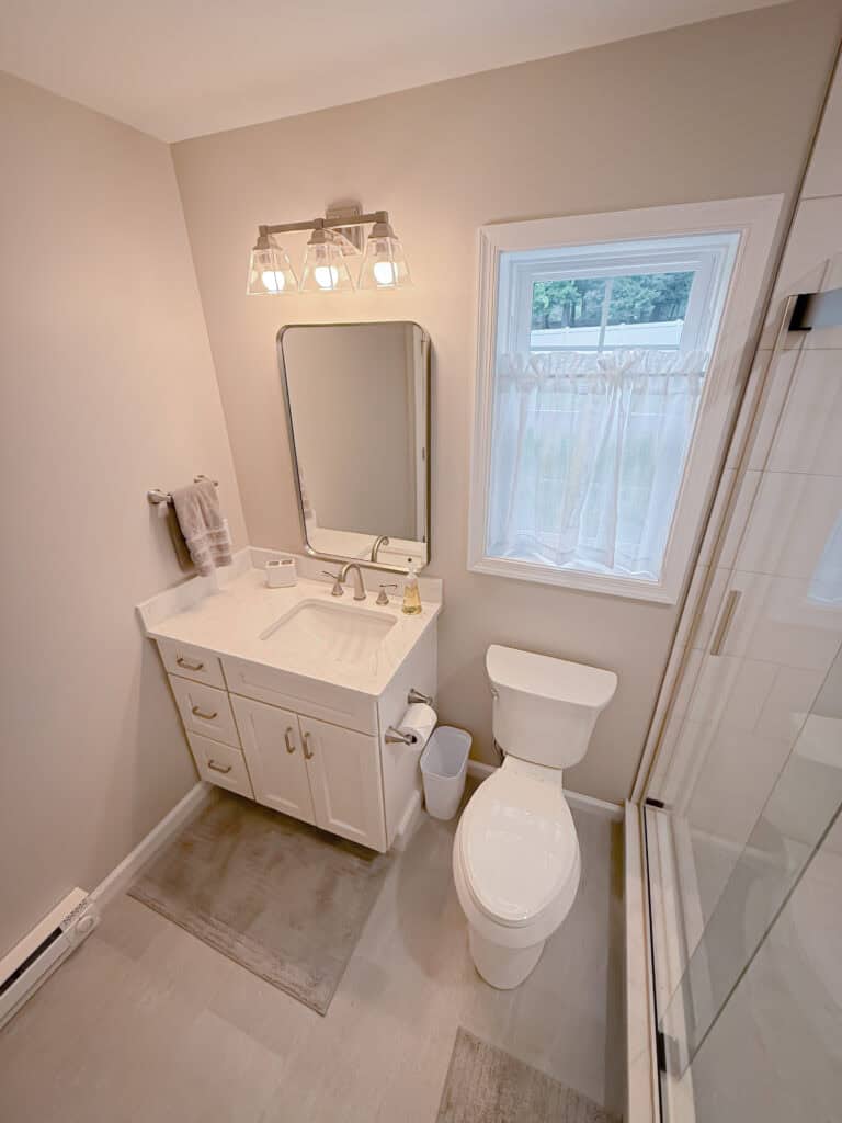 A bathroom with a toilet, sink and shower.