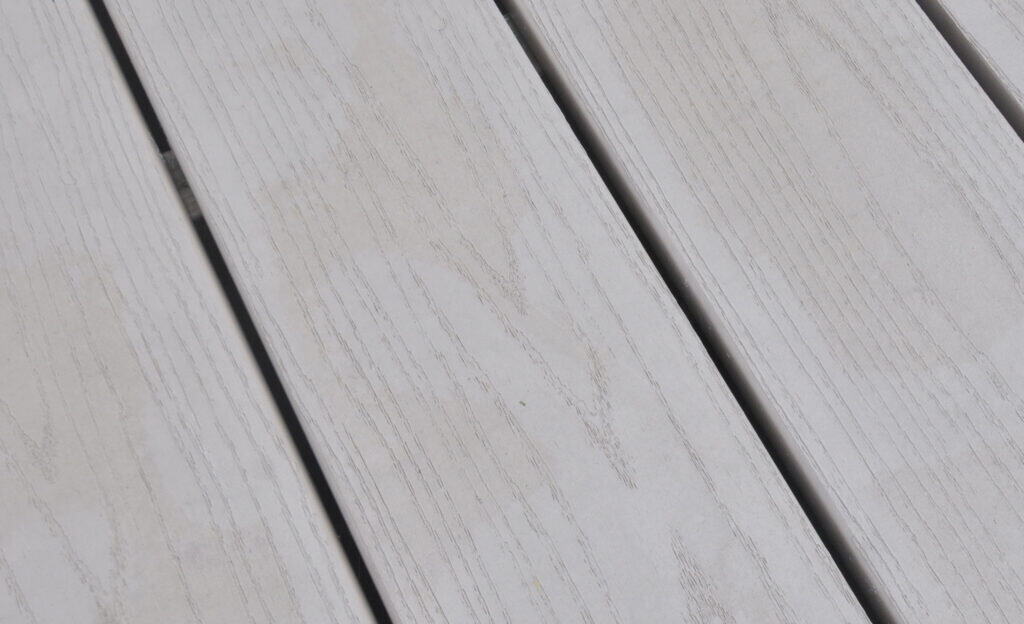 Close-up of light gray wooden planks arranged side by side, showing natural wood grain texture and subtle lines.