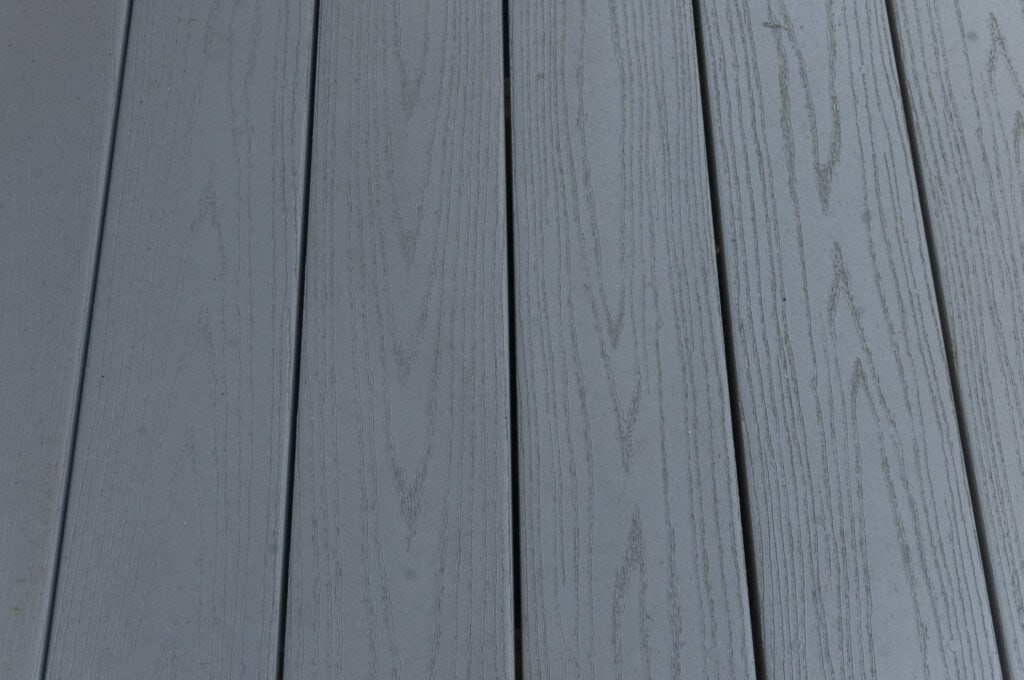 Close-up view of several gray wooden planks arranged side by side, showing subtle wood grain patterns and faint texture.