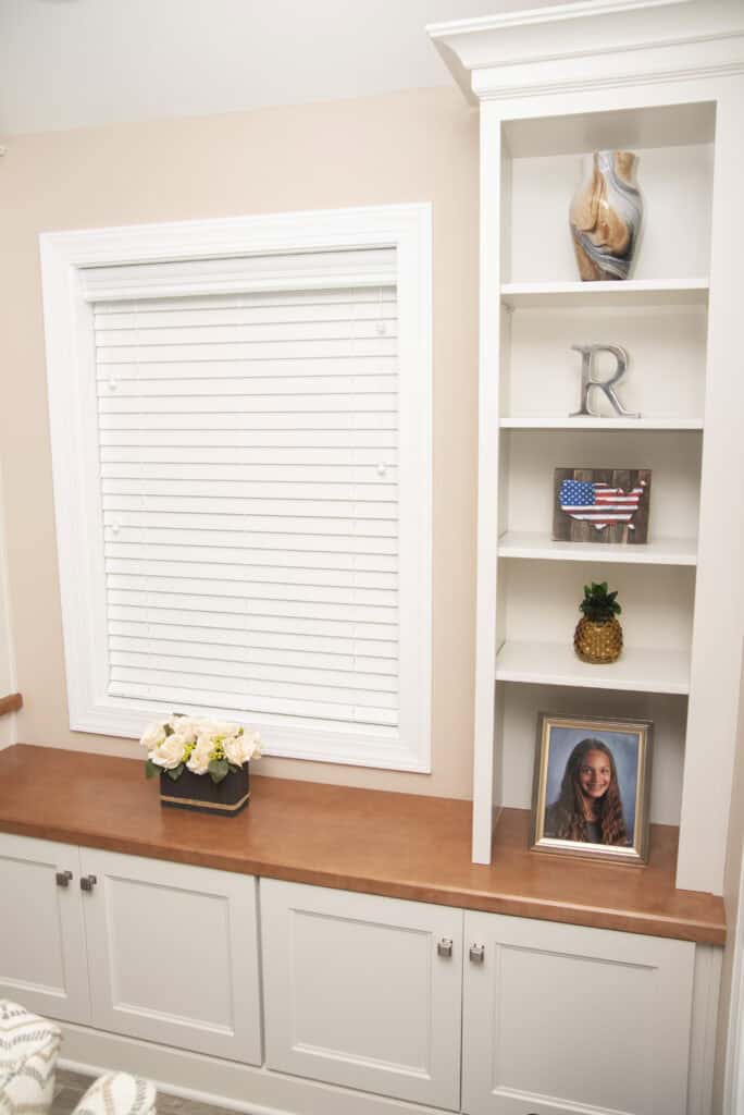 A window with blinds and shelves.