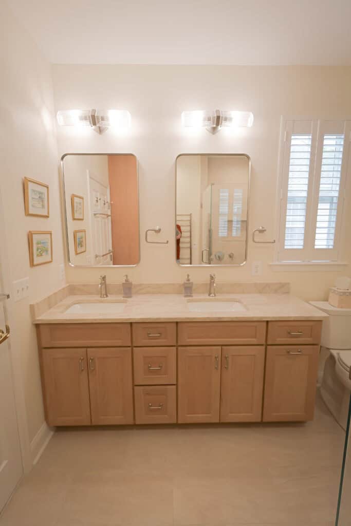 Bathroom vanity with dual sinks and large mirrors in a modern bathroom.