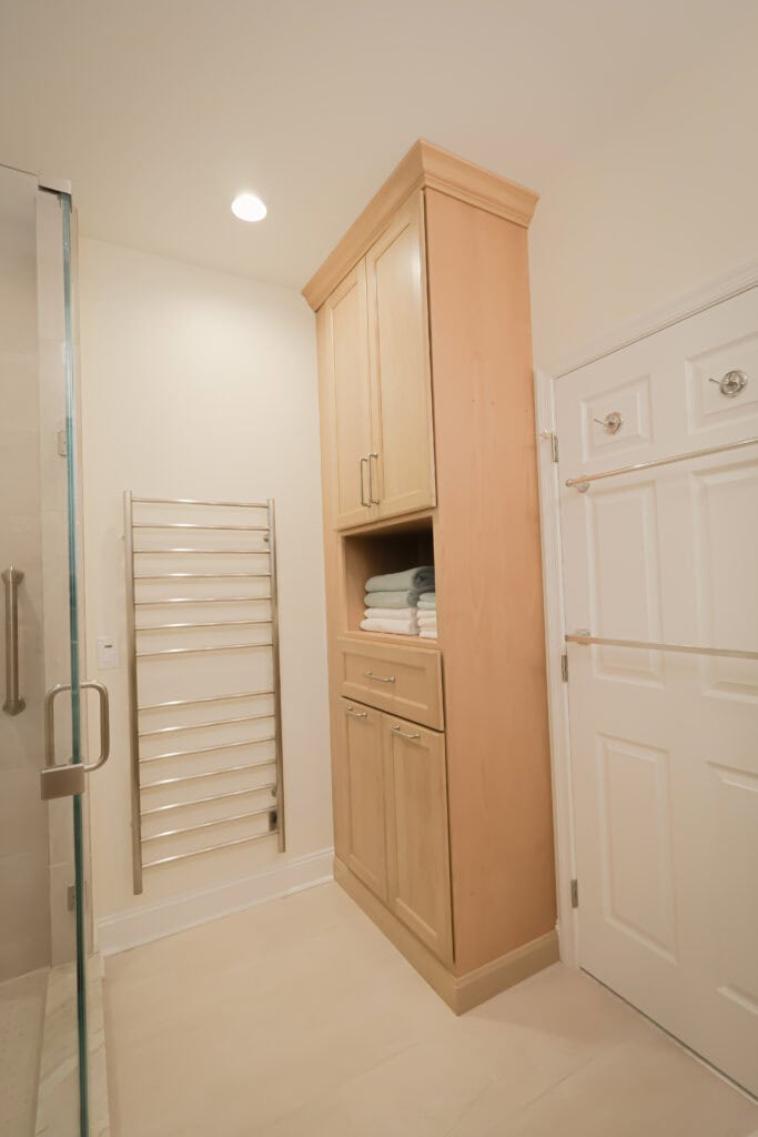 Custom bathroom storage cabinet with towels in a modern bathroom.