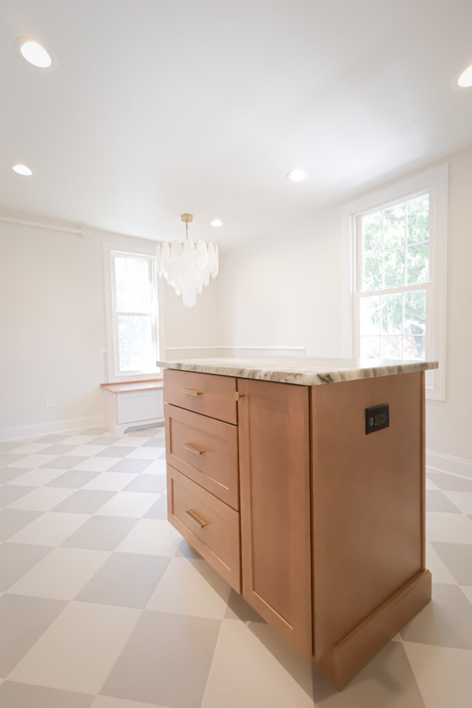 Contemporary kitchen island with wooden cabinetry and marble countertop.