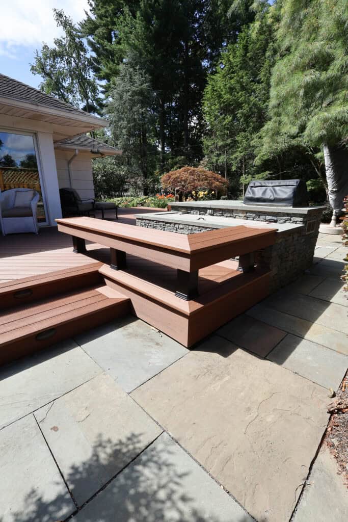 Beautiful backyard deck with fire pit and seating area by Munz Construction.