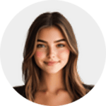 A young woman with long brown hair and subtle waves, smiling softly, is photographed against a plain, light background. She is wearing a dark top and facing the camera.