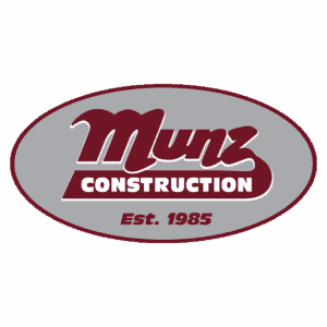A maroon and gray oval logo with the text Munz Construction in bold letters and Est. 1985 underneath.