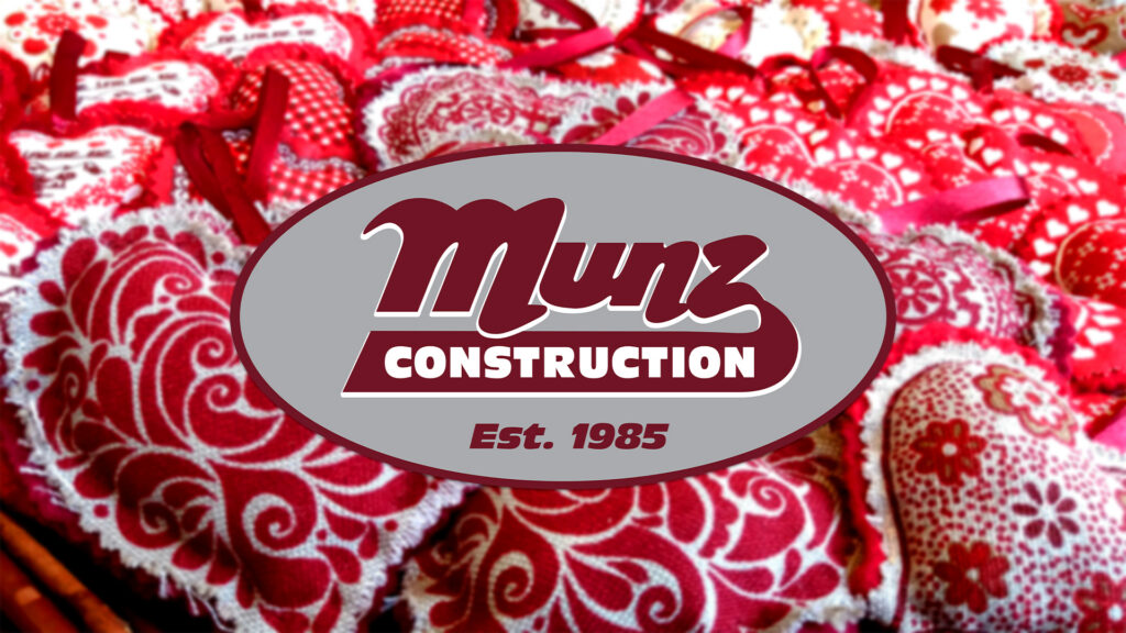A Munz Construction logo with “Est. 1985” is centered over a background of red and white patterned fabric hearts, some with lace edges and ribbon loops—perfect inspiration to plan a summer ready deck in winter.