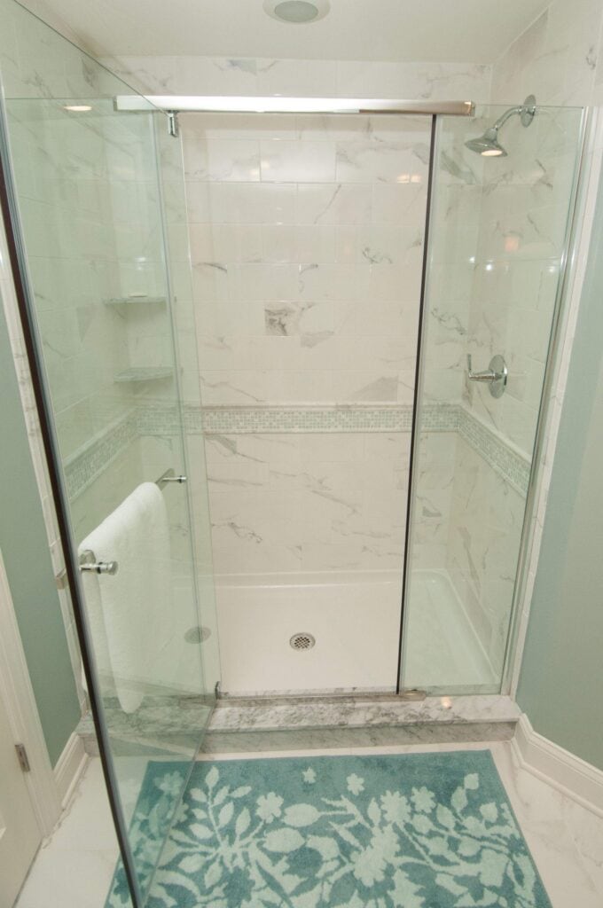 Glass shower enclosure with sleek hardware in a basement bathroom.
