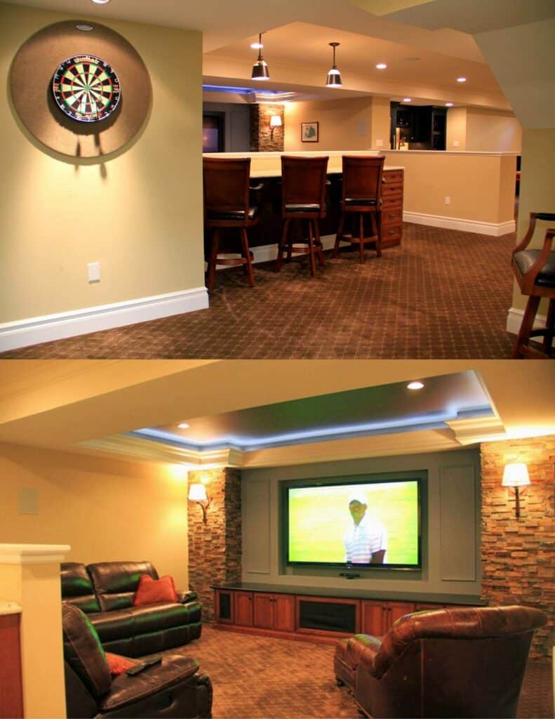 a finished basement with a dartboard, bar with stools, and a seating area facing a large tv. the decor includes warm lighting, brown carpets, and stone accents around the bar and tv.