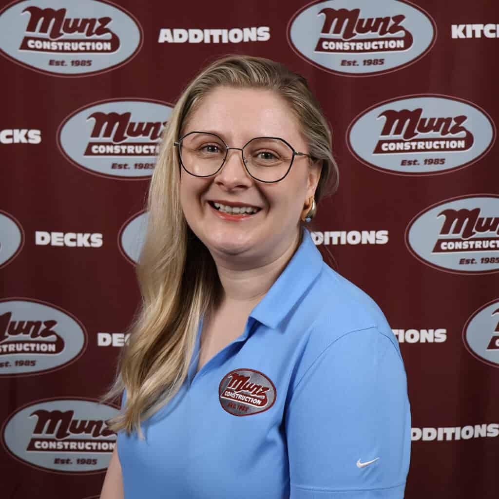 Team member at Munz Construction smiling in front of company backdrop.