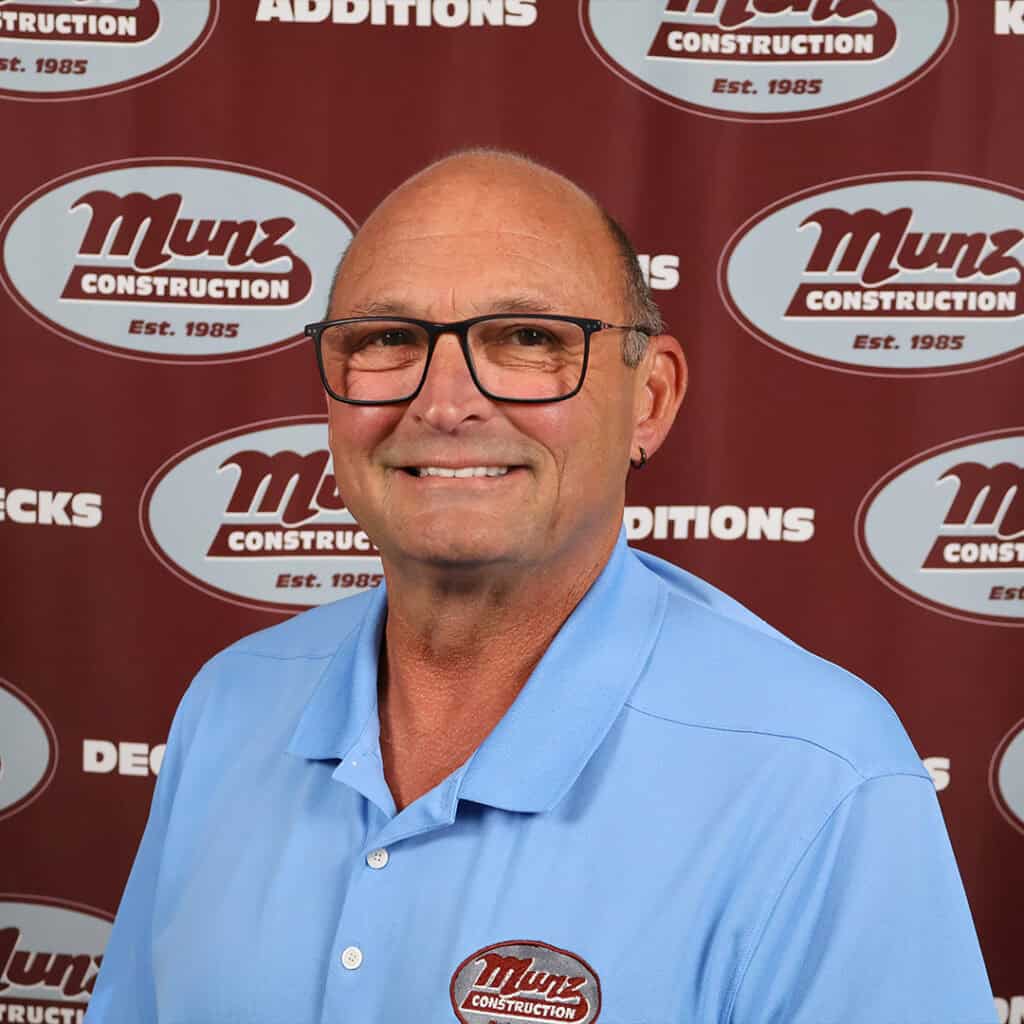 Portrait of a Munz Construction team member in front of company backdrop.