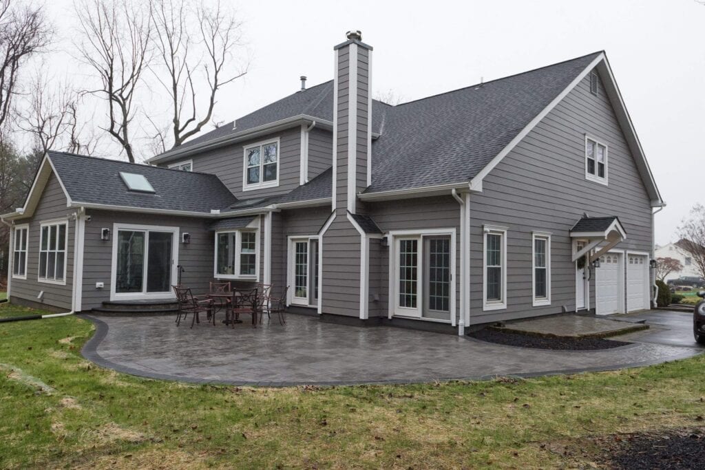 Roofing and siding installation on a contemporary gray house.