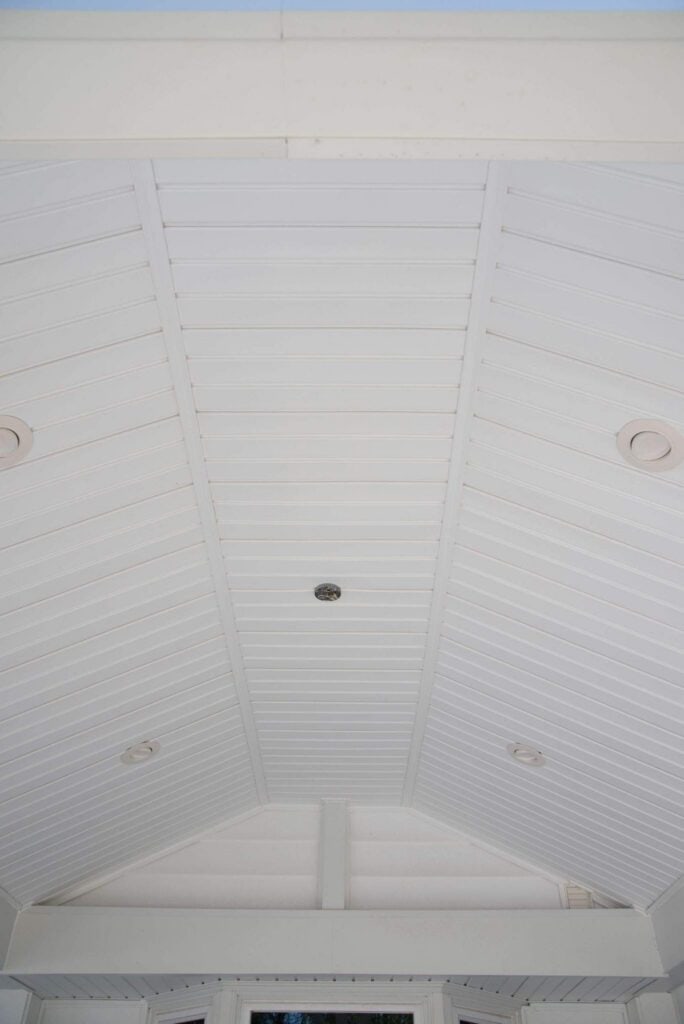 a white, vaulted ceiling with evenly spaced recessed lights and a central fixture. the ceiling panels are arranged in a symmetrical pattern, creating clean, straight lines.