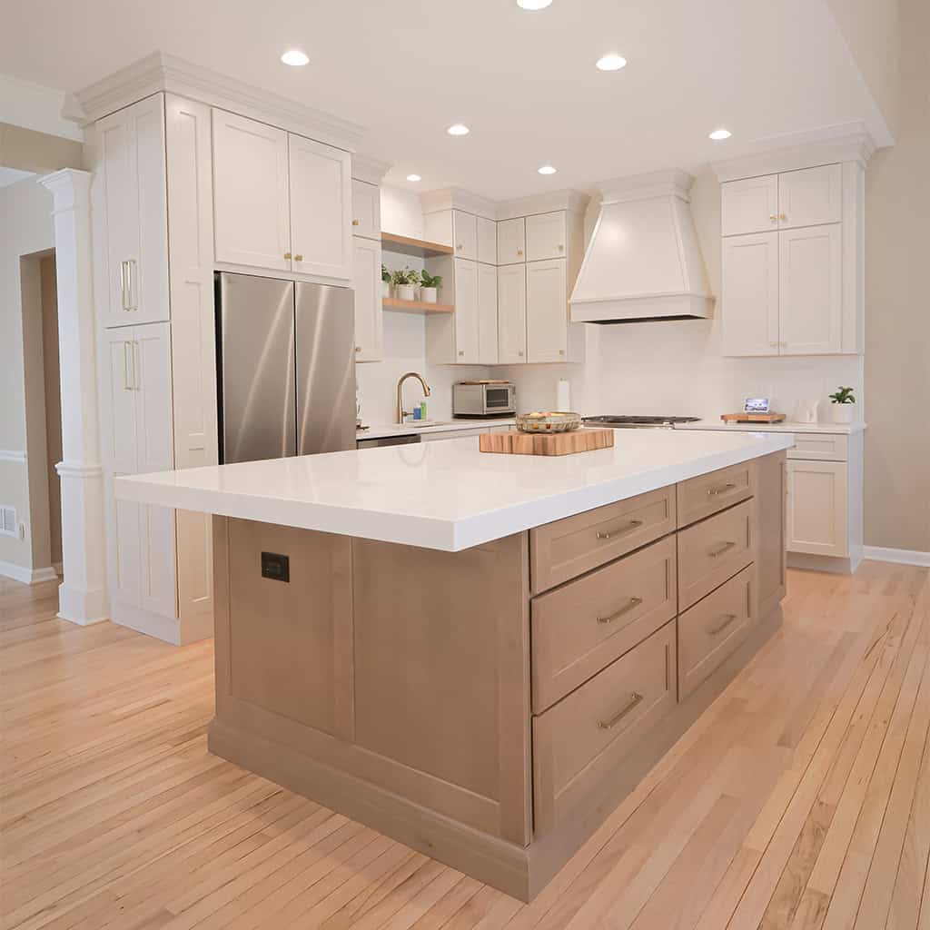 modern kitchen with white cabinets, a large stainless steel fridge, built in microwave, and a spacious island with wood drawers and a white countertop. light wood flooring and recessed ceiling lights brighten the space. modern kitchen with white cabinets, a large stainless steel fridge, built in microwave, and a spacious island with wood drawers and a white countertop. light wood flooring and recessed ceiling lights brighten the space.