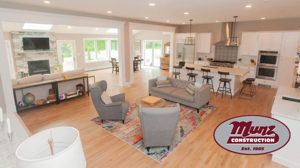 Spacious open-concept living room with large windows and modern kitchen.
