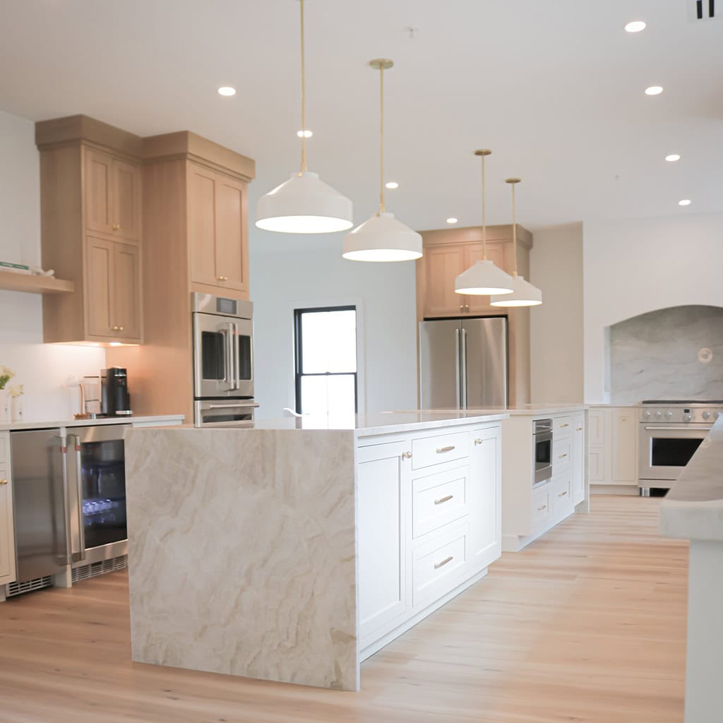 Contemporary kitchen with island, pendant lights, and stainless steel appliances.