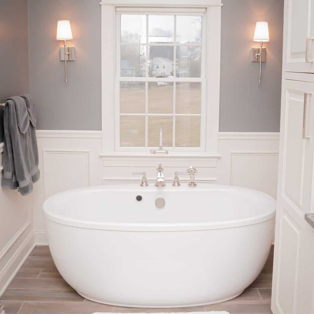 Elegant bathroom with a white freestanding bathtub and modern lighting fixtures.