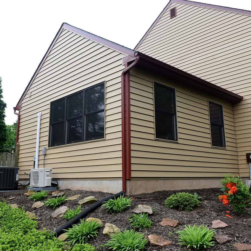 Exterior view of a new in-law suite with beige siding and black windows.