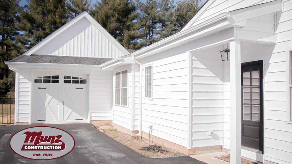 White in-law suite with garage and side door, modern design, and outdoor lighting.
