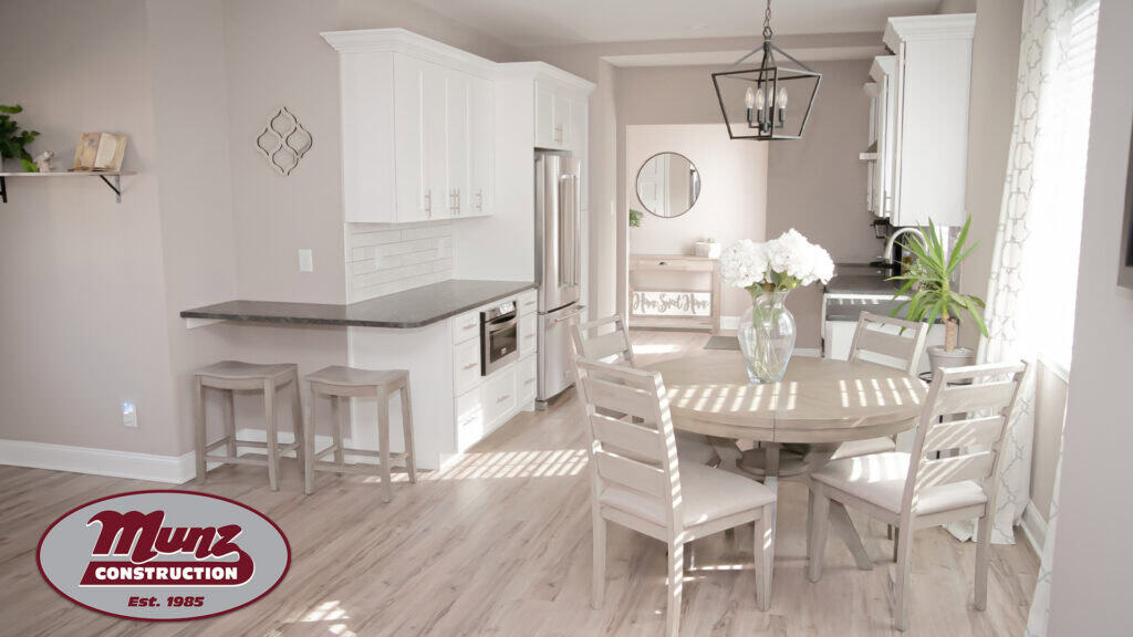 Bright, modern kitchen with white cabinets and a round dining table.