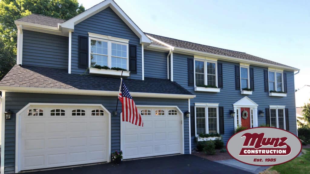 Modern blue house with white trim and attached garage, perfect for home additions.