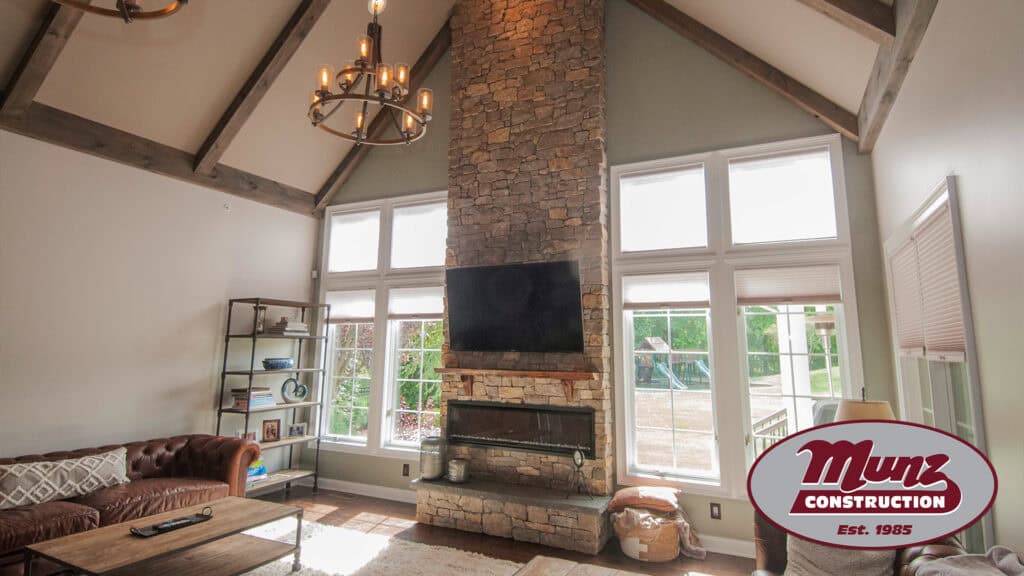 Spacious living room with stone fireplace and large windows.