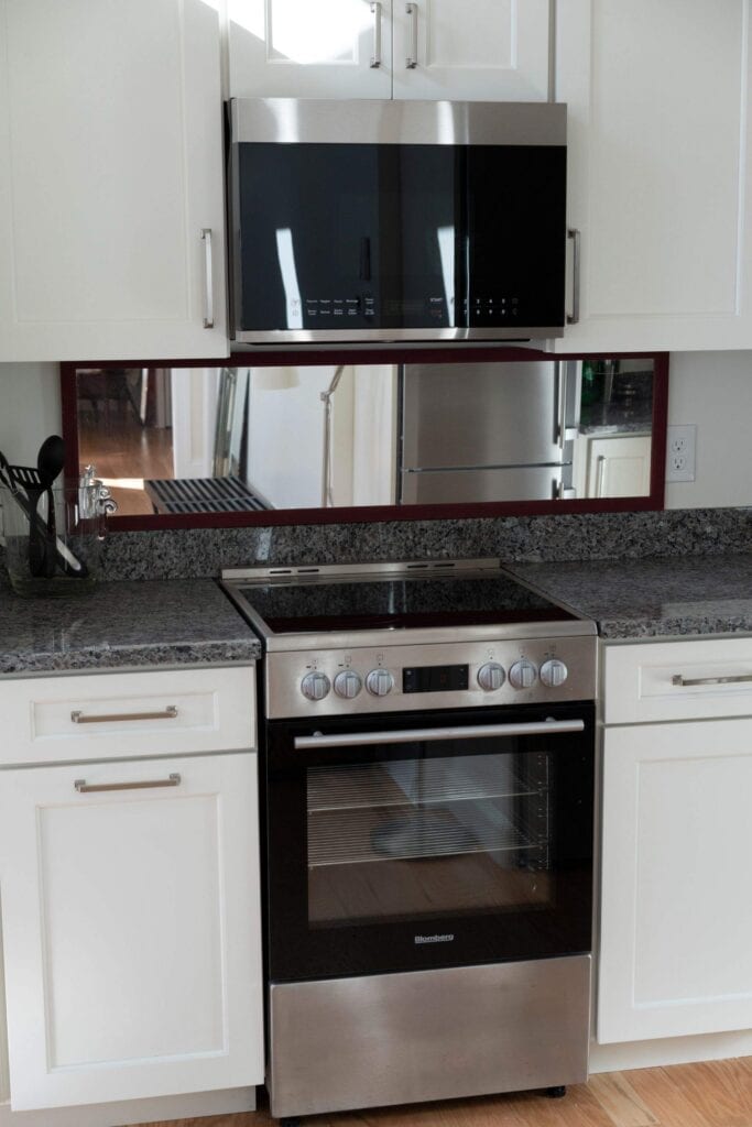 Kitchen with stainless steel oven, microwave, and white cabinets.