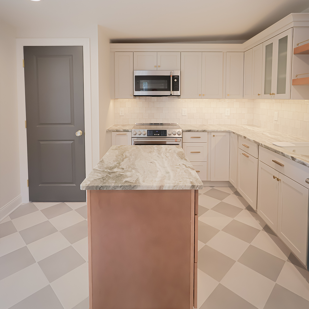 modern kitchen with white cabinets, a gray door, marble countertop island, stainless steel appliances, tiled backsplash, and checkered light gray flooring under bright lighting. modern kitchen with white cabinets, a gray door, marble countertop island, stainless steel appliances, tiled backsplash, and checkered light gray flooring under bright lighting.